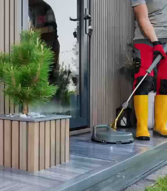 Everest Crew Clean team member cleaning a deck with a surface cleaner