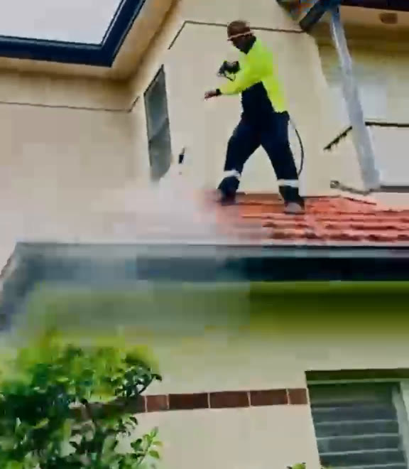 Everest Crew Clean team member soft washing the outside of a house