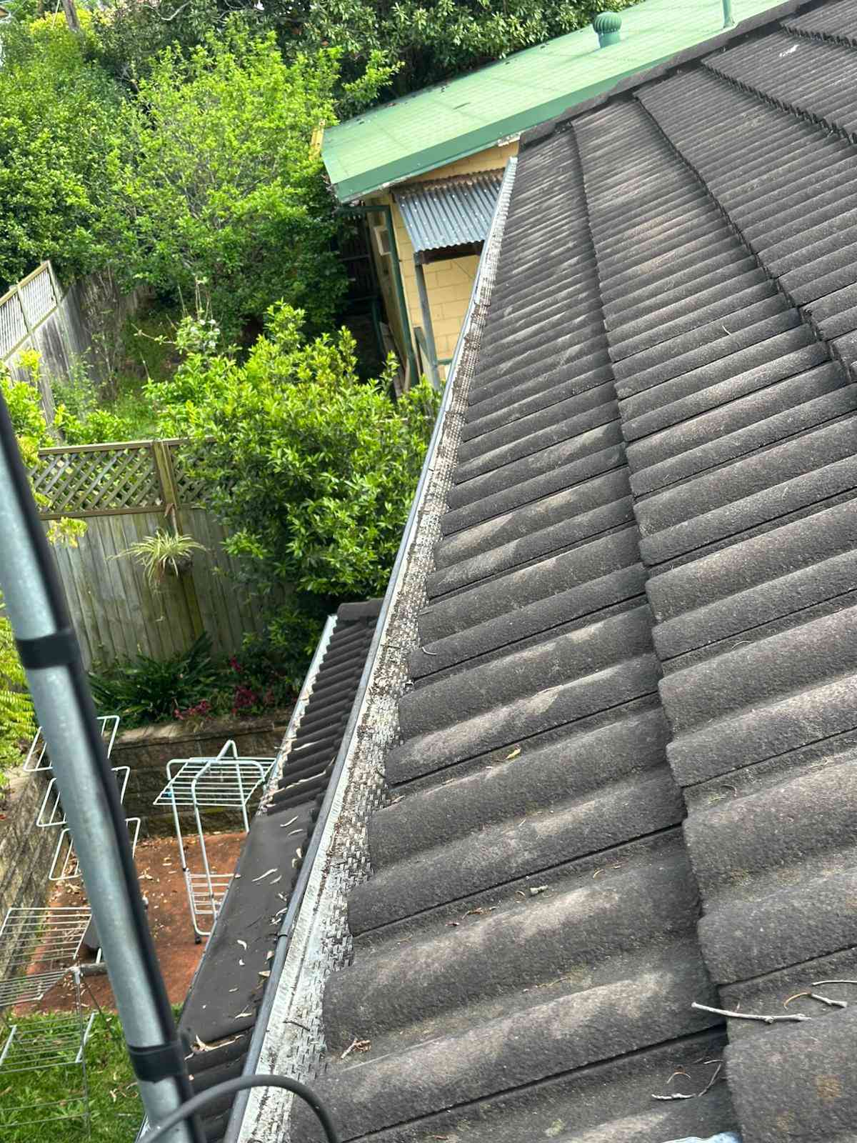 Gutter along a tiled roof after cleaning